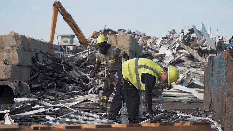 Two Wall Recycling employees working in a scrap yard.