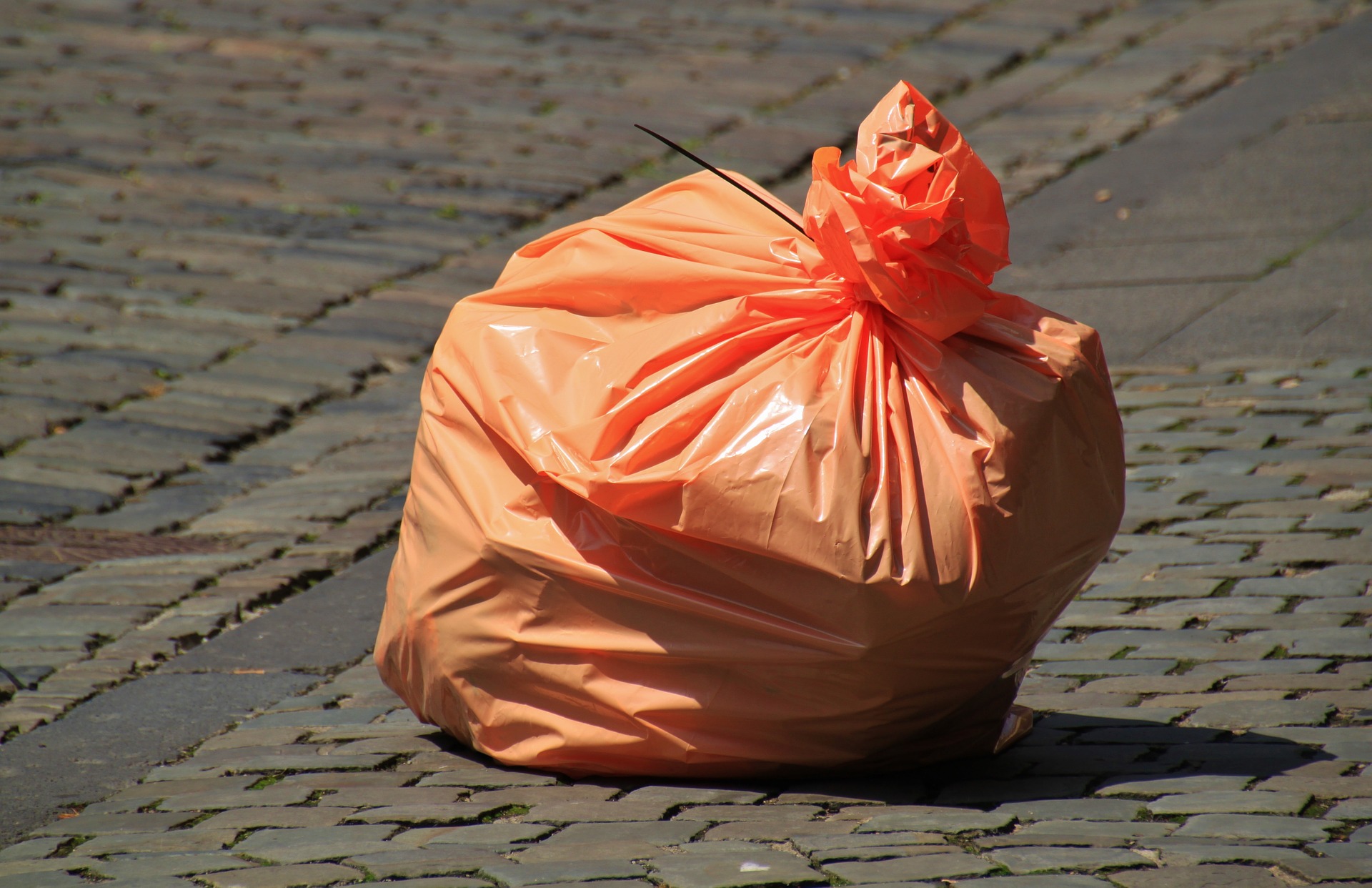 WallRecycling-trashbag orange trash bag to be thrown into a rented dumpster