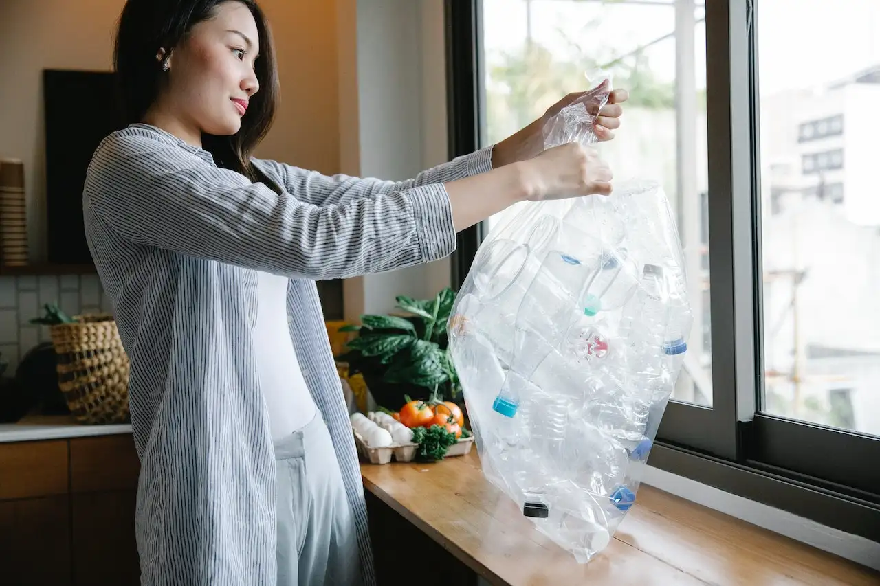 how-to-dispose-of-household-items Woman recycling plastic bottles after learning how to dispose of household items